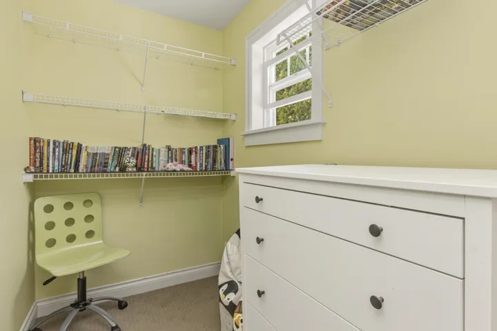 Walk in closet featuring light carpet, a window and shelving in bedroom #2