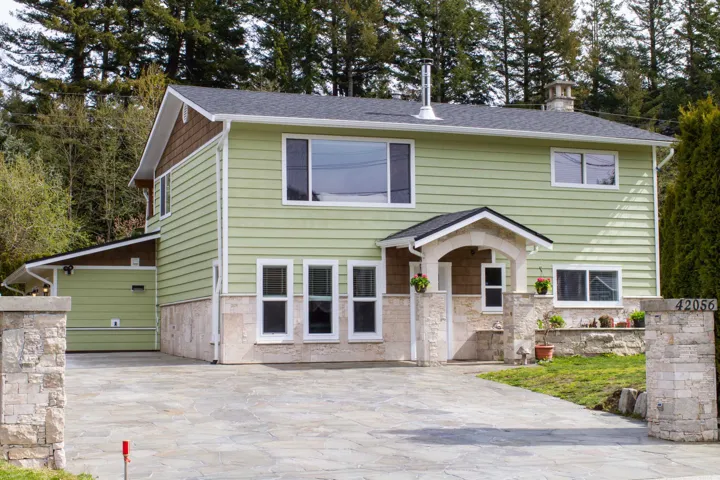 Light green horizontal siding with stone veneer accents
