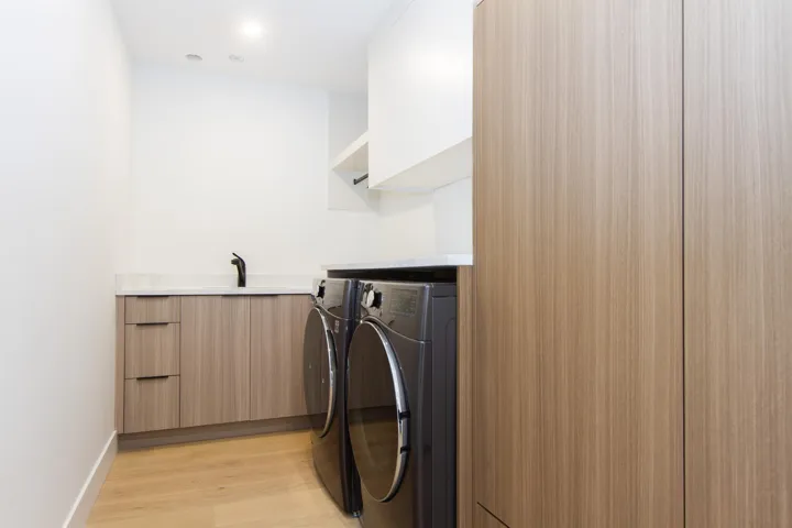 Clothes washing area with washer and dryer, light wood-type flooring, and baseboards