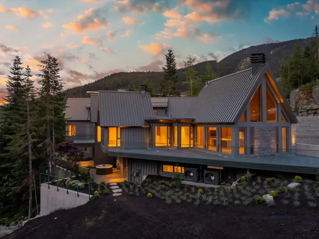 Back of property at dusk featuring a chimney, a mountain view, and board and batten siding