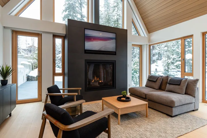 Living area with light wood-style floors, a glass covered fireplace, plenty of natural light, wooden ceiling, and high vaulted ceiling