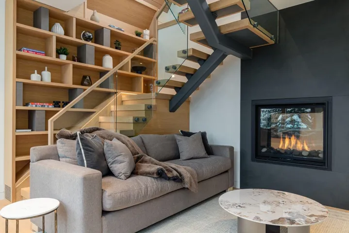 Living area featuring stairs and a multi sided fireplace