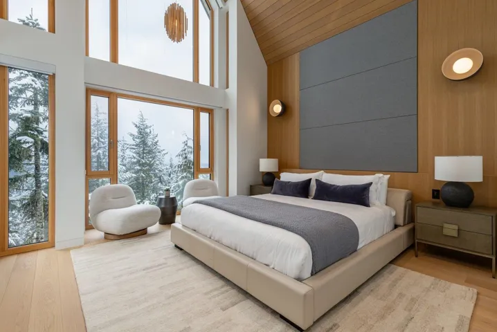 Bedroom with wood finished floors, high vaulted ceiling, an accent wall, and wooden walls