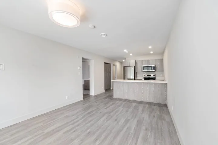 Unfurnished living room featuring baseboards, light wood finished floors, and recessed lighting
