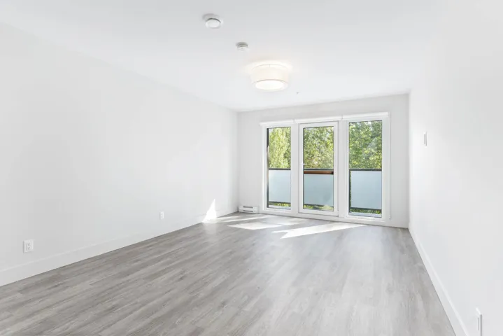 Spare room featuring wood finished floors, baseboards, a smoke detector, and baseboard heating