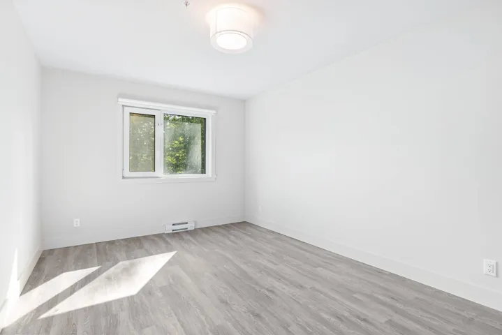Unfurnished room with wood finished floors and baseboards