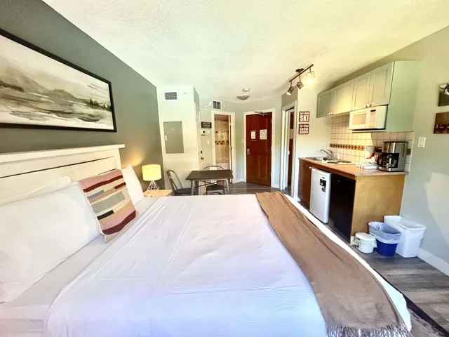 Bedroom with a textured ceiling, wood finished floors, and electric panel