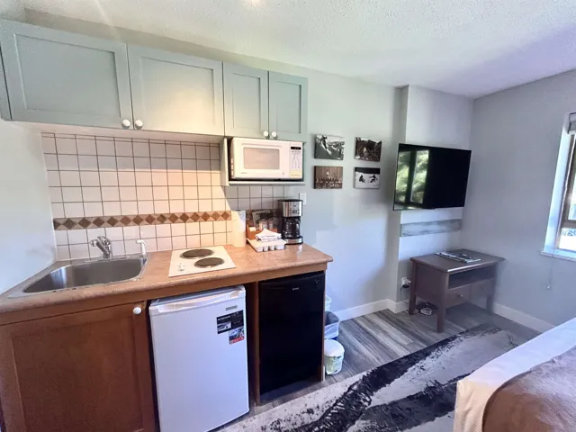 Kitchen featuring white appliances, light countertops, decorative backsplash, healthy amount of natural light, and a textured ceiling