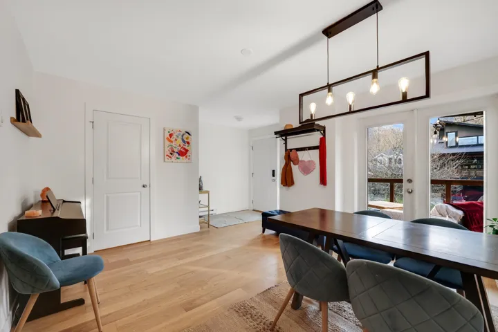 Dining area featuring wood-finish flooring and a rectangular pendant light fixture