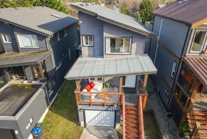 Modern multi-level residence featuring a charcoal gray facade and prominent front deck