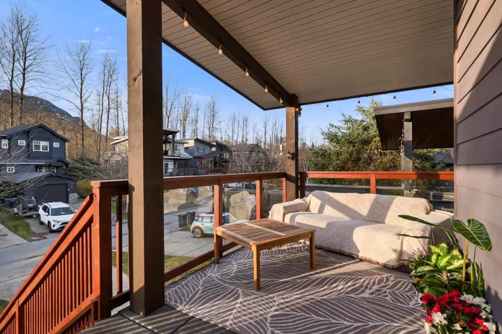 Covered outdoor deck featuring wood-look decking, a slat wood ceiling, and integrated string lighting