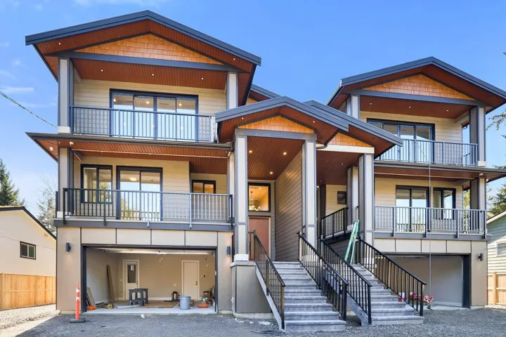 View of front of house featuring an attached garage, a patio, and driveway