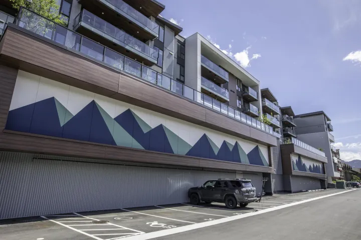 View of apartment building / complex with uncovered parking