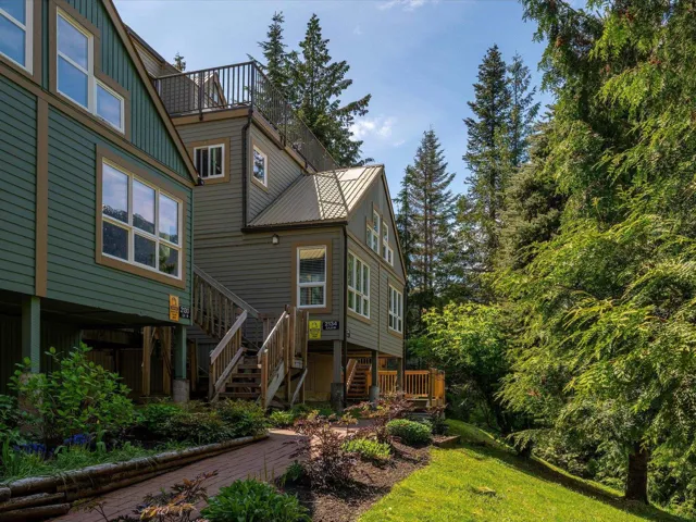 Rear view of house featuring stairs, board and batten siding, and metal roof