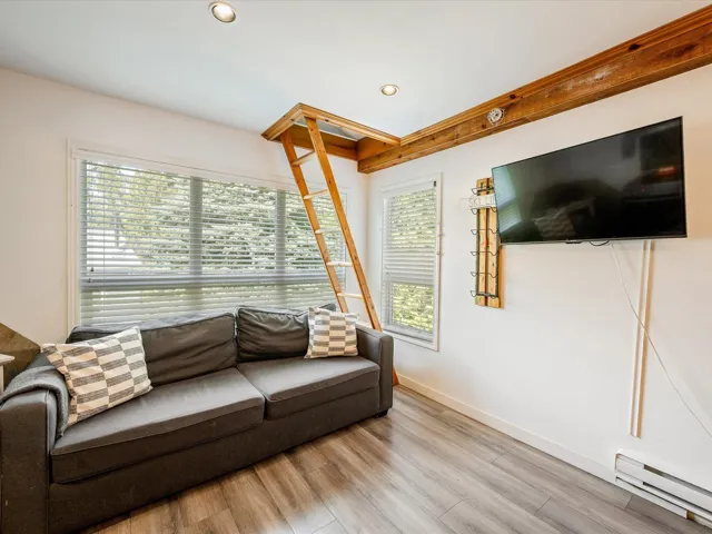Living area featuring baseboard heating, plenty of natural light, wood finished floors, recessed lighting, and baseboards