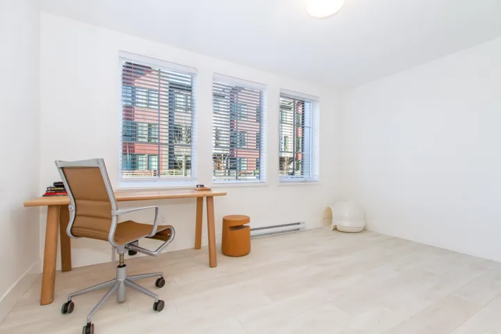 Office space with baseboard heating, wood finished floors, and baseboards