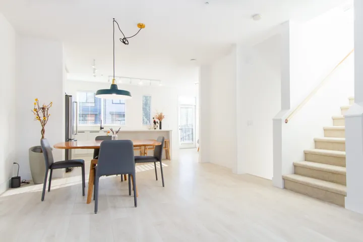Dining room featuring stairway, light wood-type flooring, and rail lighting