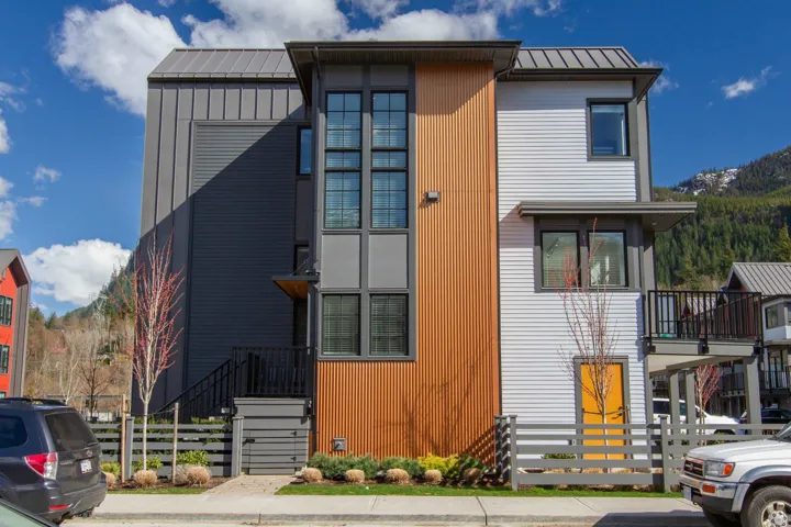 Modern home with board and batten siding, a standing seam roof, and metal roof