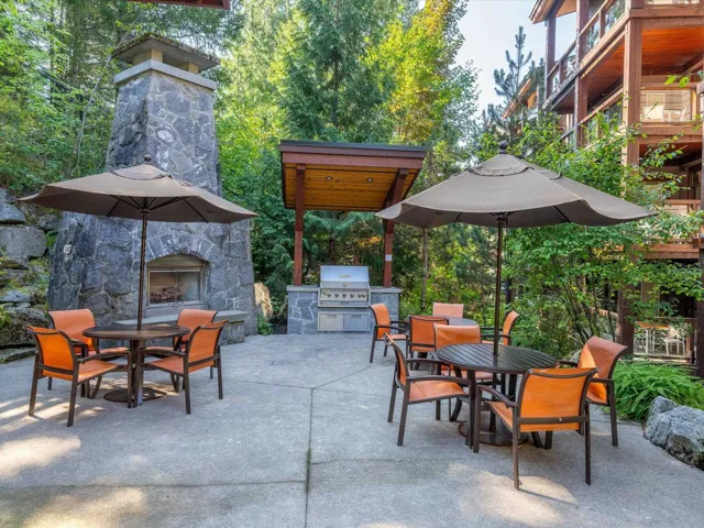 View of patio featuring outdoor dining space, an outdoor stone fireplace, and exterior kitchen