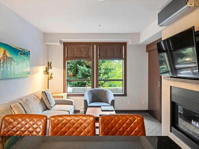 Carpeted living room with an AC wall unit and a fireplace with flush hearth