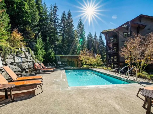 Community pool featuring a patio area and view of scattered trees