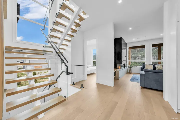 Floating staircase featuring wood-finish treads and clear glass railings