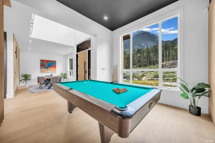 Spacious room featuring light wood-finish flooring and a prominent window framing a mountainous landscape