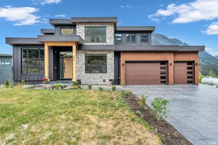 Contemporary multi-level exterior featuring stone veneer and dark vertical siding