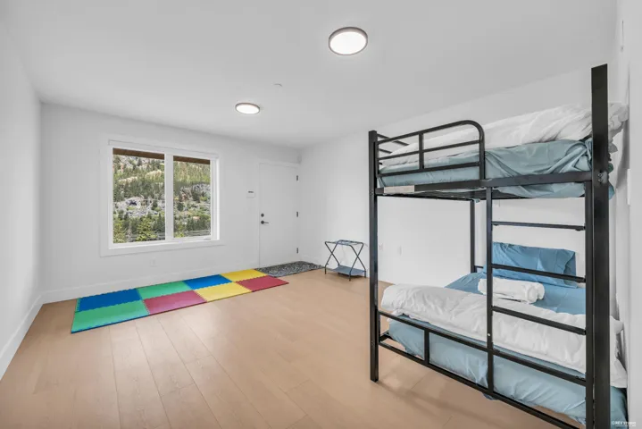 Bright room featuring light wood-finish flooring, white walls, and a large window
