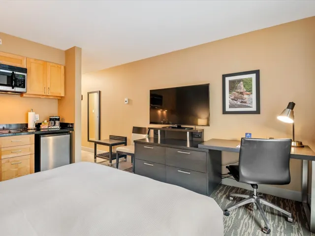 Bedroom with stainless steel refrigerator and an office area
