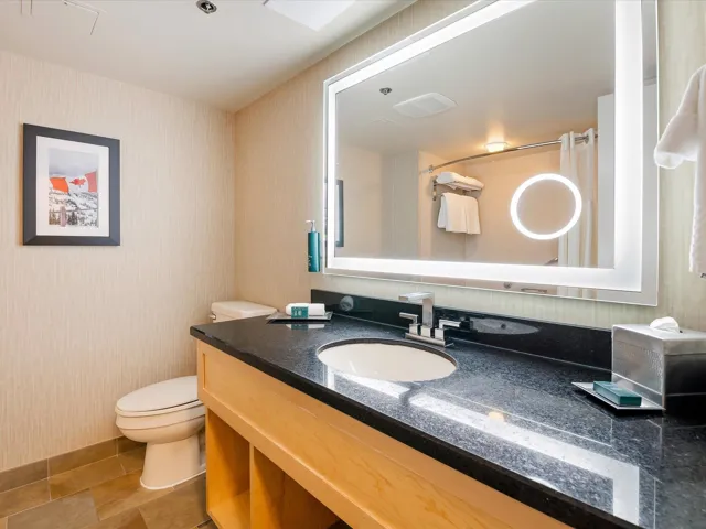 Bathroom with vanity, wallpapered walls, and curtained shower