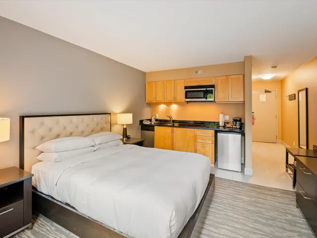Bedroom with light tile patterned floors and stainless steel fridge