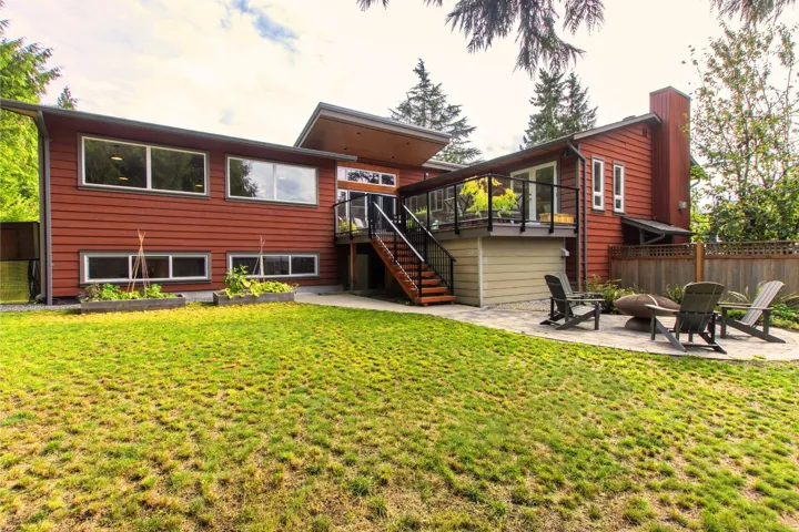 Back of property featuring stairs, a patio, an outdoor fire pit, and a deck