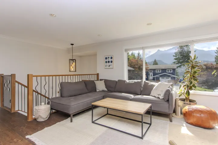 Living room with a mountain view, ornamental molding, and wood finished floors