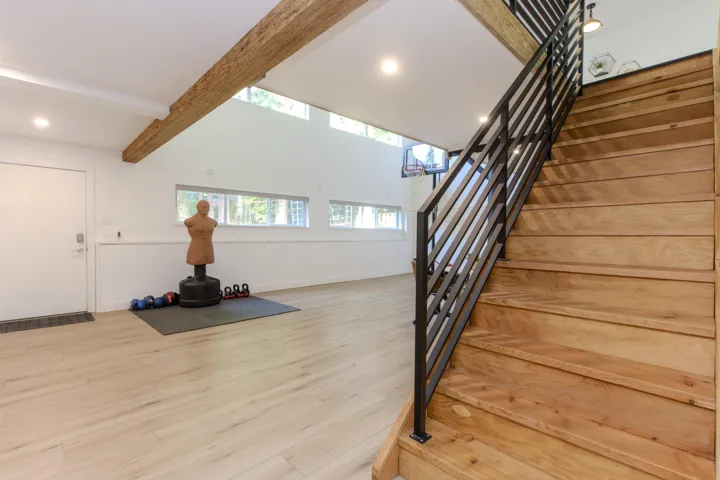 Stairway featuring wood finished floors and recessed lighting