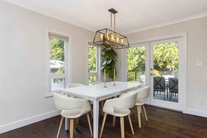 Dining room featuring dark wood-type flooring, french doors, a chandelier, and crown molding