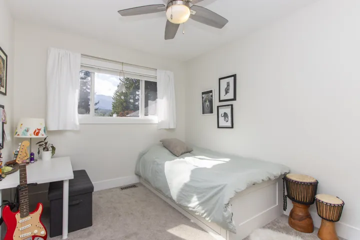 Bedroom featuring light colored carpet and a ceiling fan