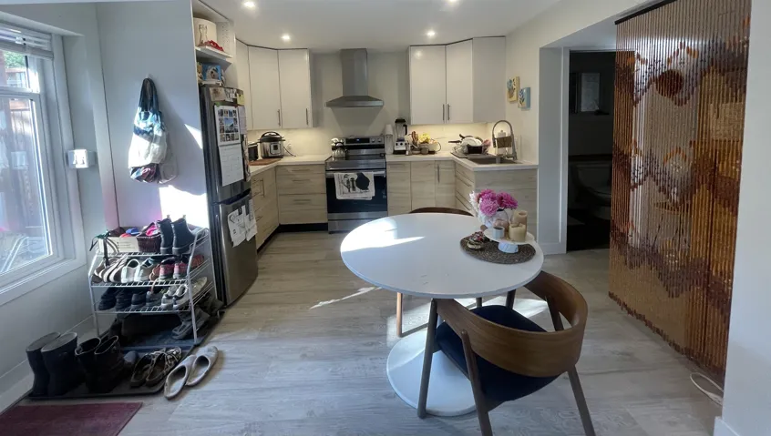 Kitchen with appliances with stainless steel finishes, light countertops, wall chimney exhaust hood, light wood-type flooring, and white cabinets