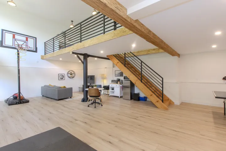 Living room featuring light wood-style flooring, recessed lighting, stairway, a towering ceiling, and beam ceiling
