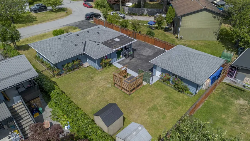 Expansive property featuring a residence with a grey shingle roof and light blue siding