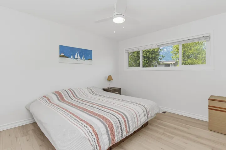 Bedroom featuring light wood-finish flooring, white walls, and a multi-pane window
