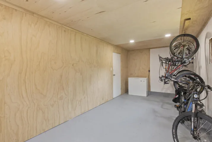 Utility room featuring light wood-finish wall paneling, a light gray floor finish, and recessed ceiling lighting
