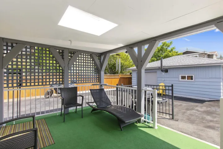 Covered patio area featuring a white ceiling, integrated skylight, and a green turf floor