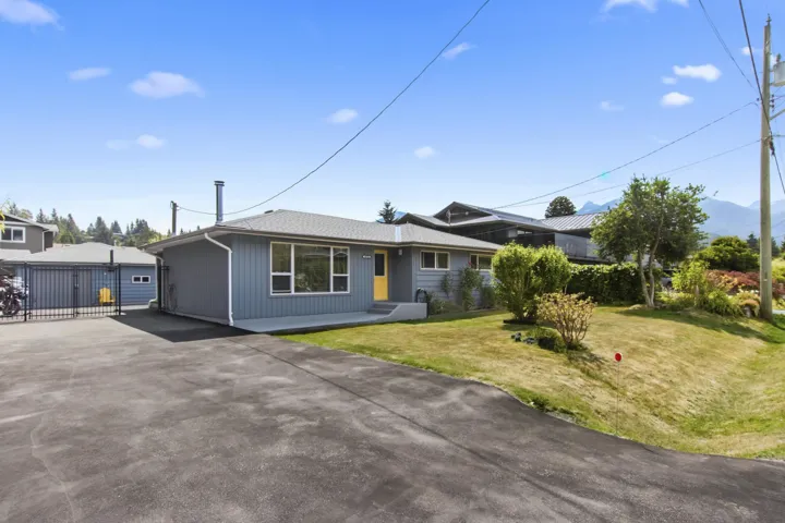 Ranch-style residence featuring grey siding and a vibrant yellow entry door