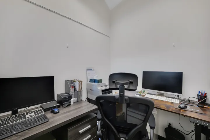 Dedicated workspace featuring white walls and two wood-finish desks