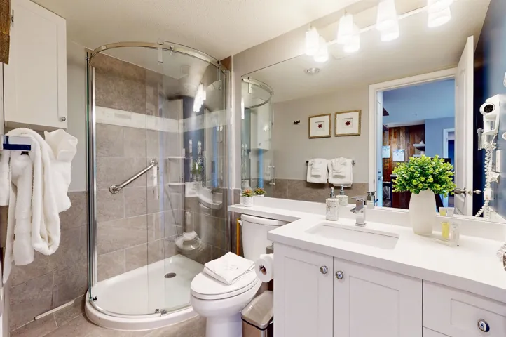 Full bathroom with toilet, a shower stall, and vanity