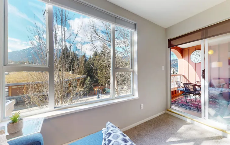 Sitting room featuring a wealth of natural light, carpet, and baseboards