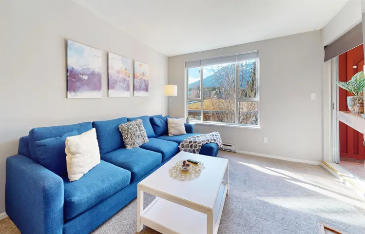 Living area with a baseboard heating unit, carpet, and baseboards