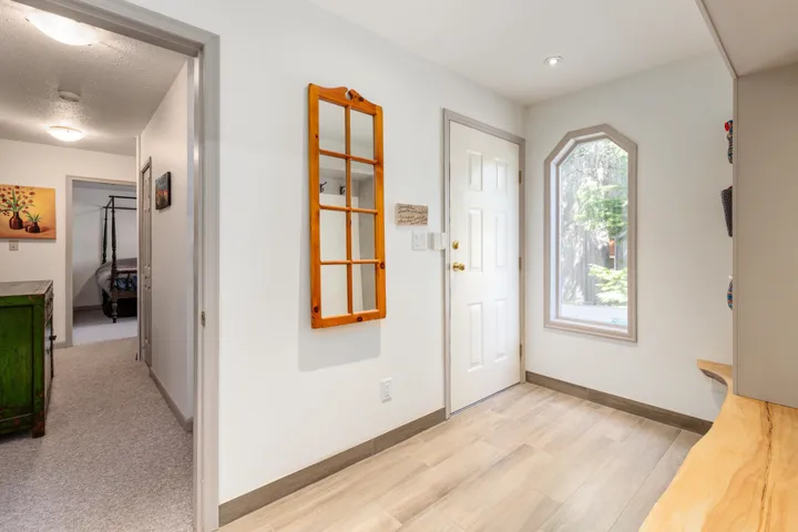 Entryway with light wood-finish flooring, a paneled door, and an arched window