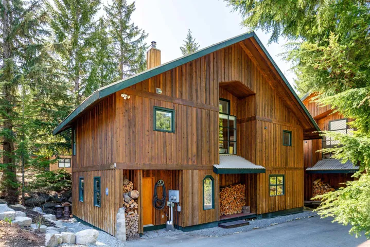 Wood-sided exterior featuring a prominent A-frame roofline and green trim